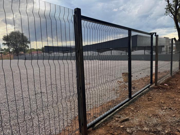 Clearview fence and gate around a gravel yard